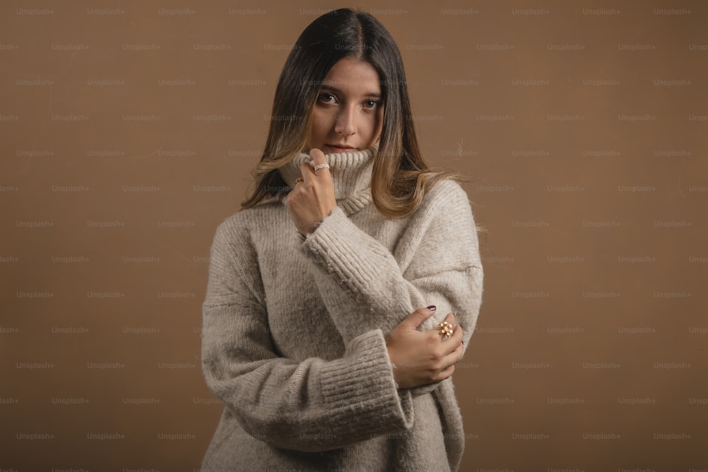 a woman in a sweater is posing for a picture