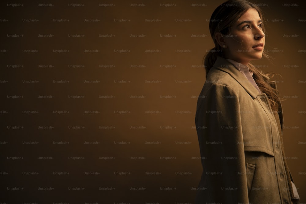 a woman in a trench coat looking off into the distance