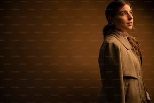 a woman in a trench coat looking off into the distance