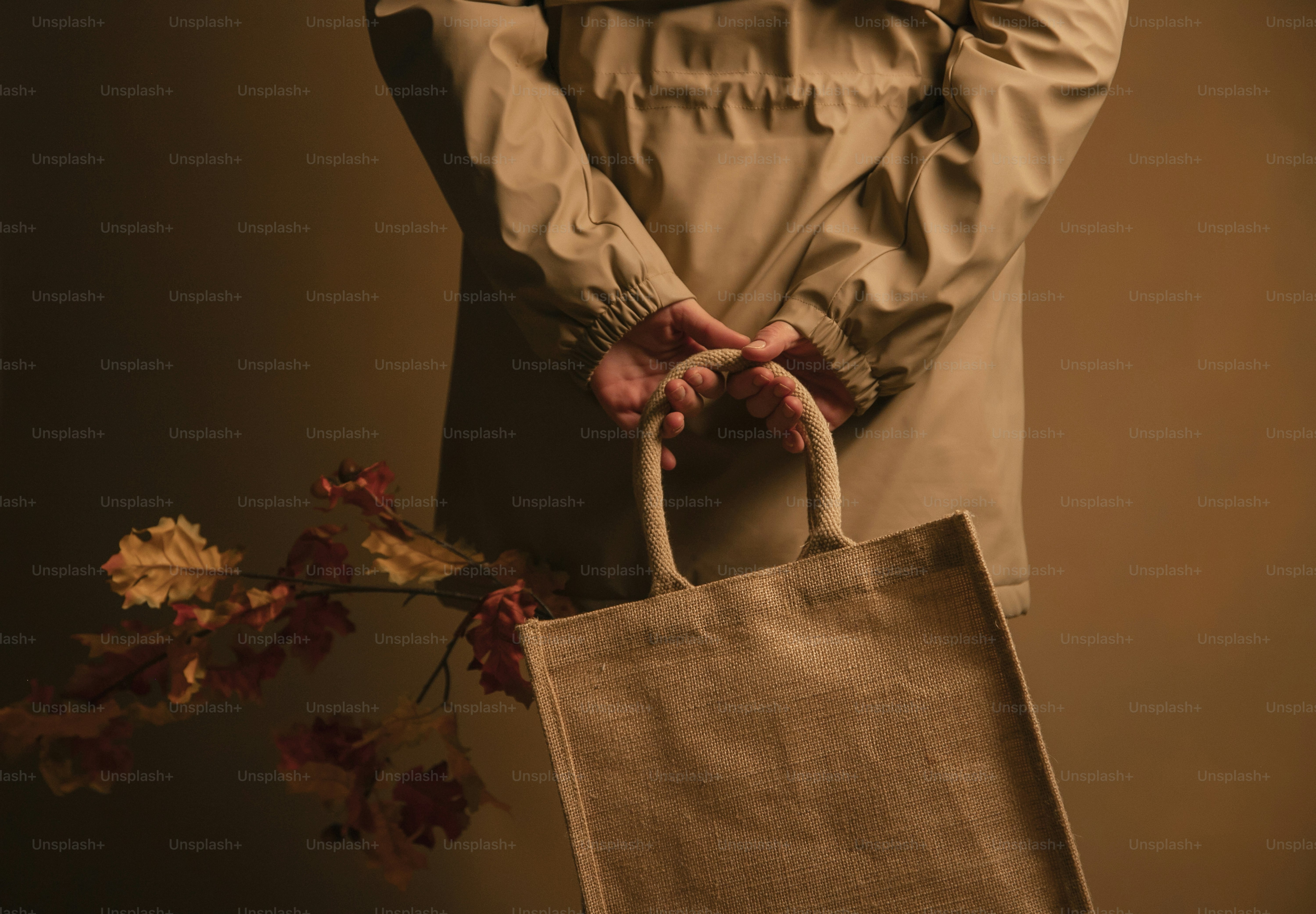 a person holding a brown bag with a plant in it