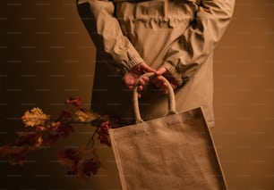 a person holding a brown bag with a plant in it