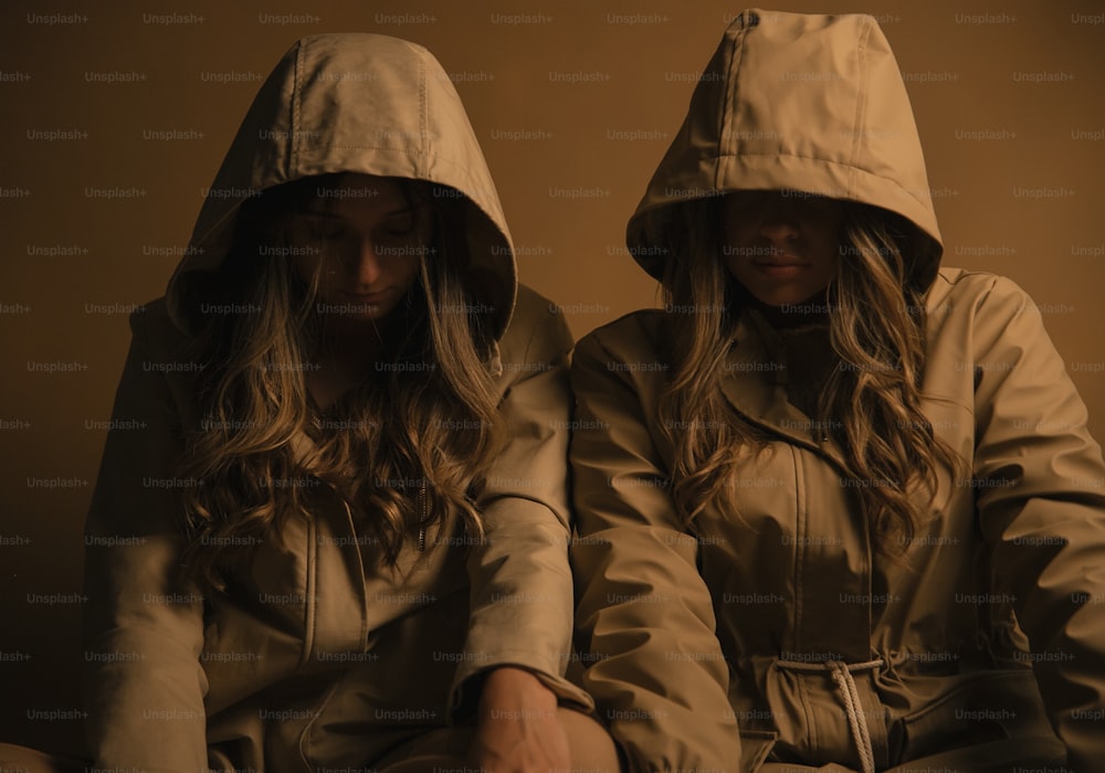 two women in hooded jackets sitting next to each other
