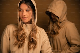 a woman in a hooded jacket standing in front of a mirror