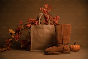 a pair of brown boots sitting next to a bag
