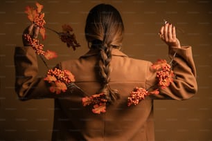 a woman in a brown coat holding a bunch of flowers