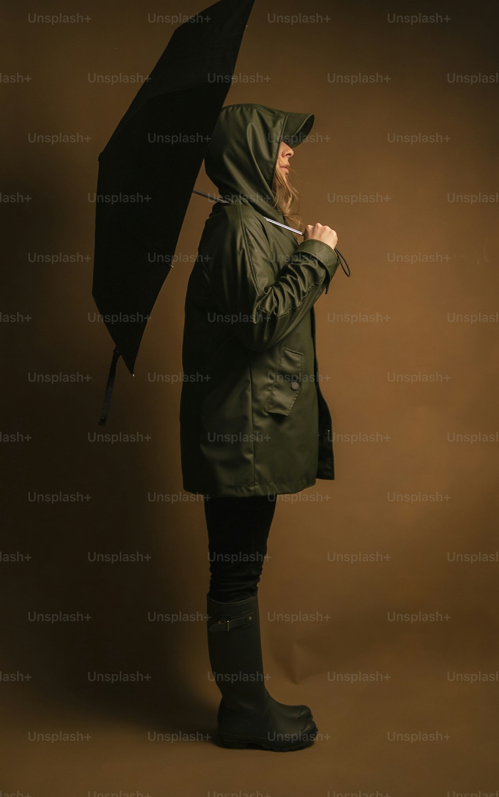 a woman in a green coat holding an umbrella