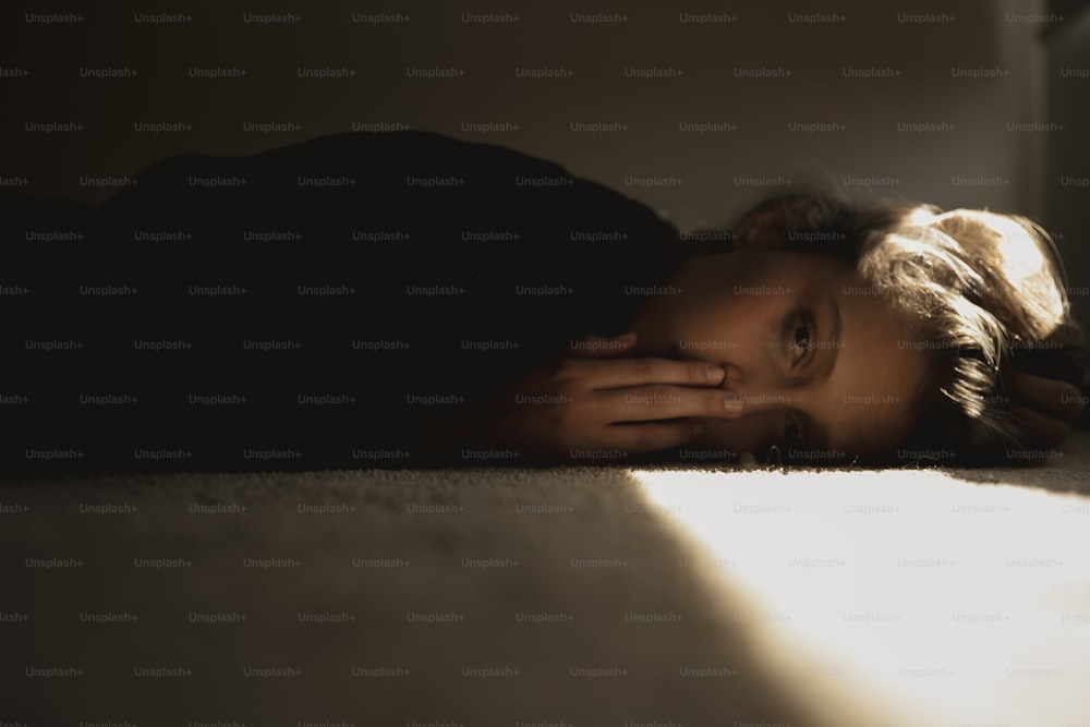 a woman laying on the floor with her head on her hands