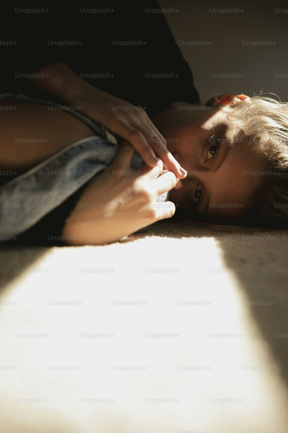 a woman laying on the floor with her hand on her face