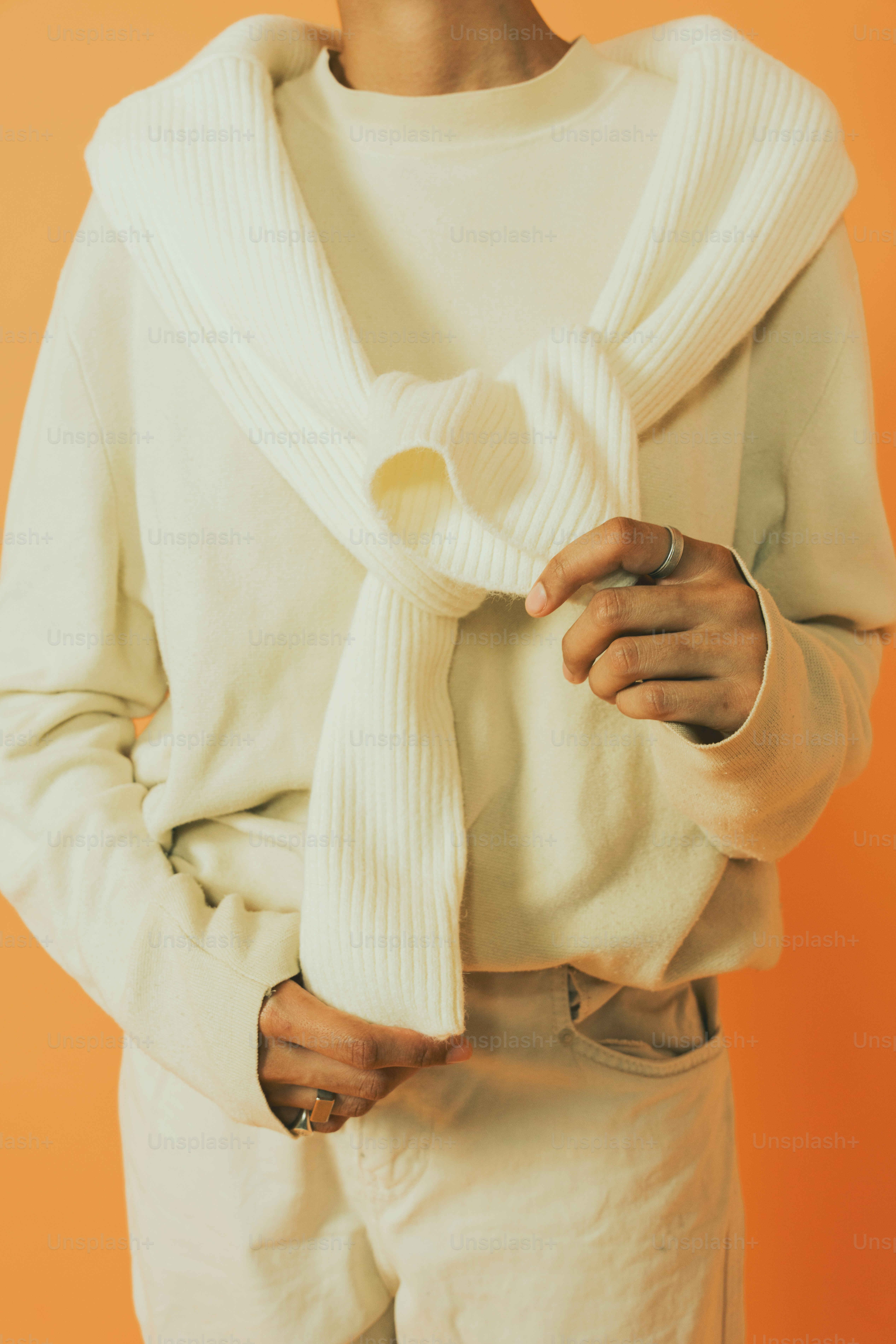 uma mulher vestindo um suéter branco e um lenço branco