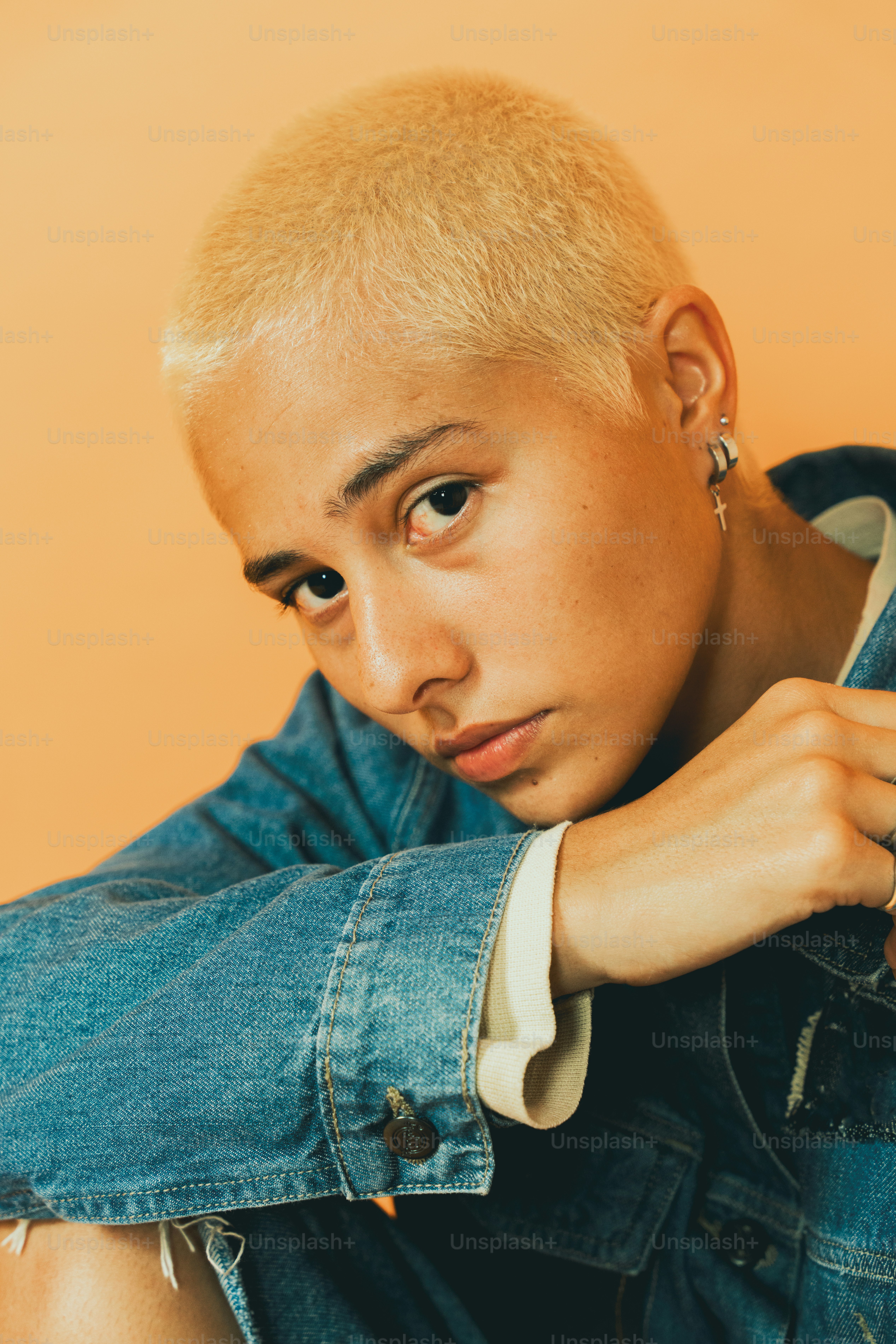 un homme au crâne rasé portant une veste en jean