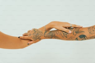 una donna con tatuaggi sul braccio che tiene il braccio di un'altra donna