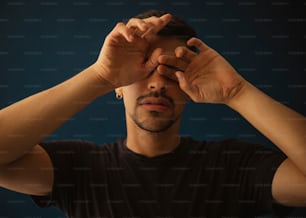 a man holding his hands up to his face