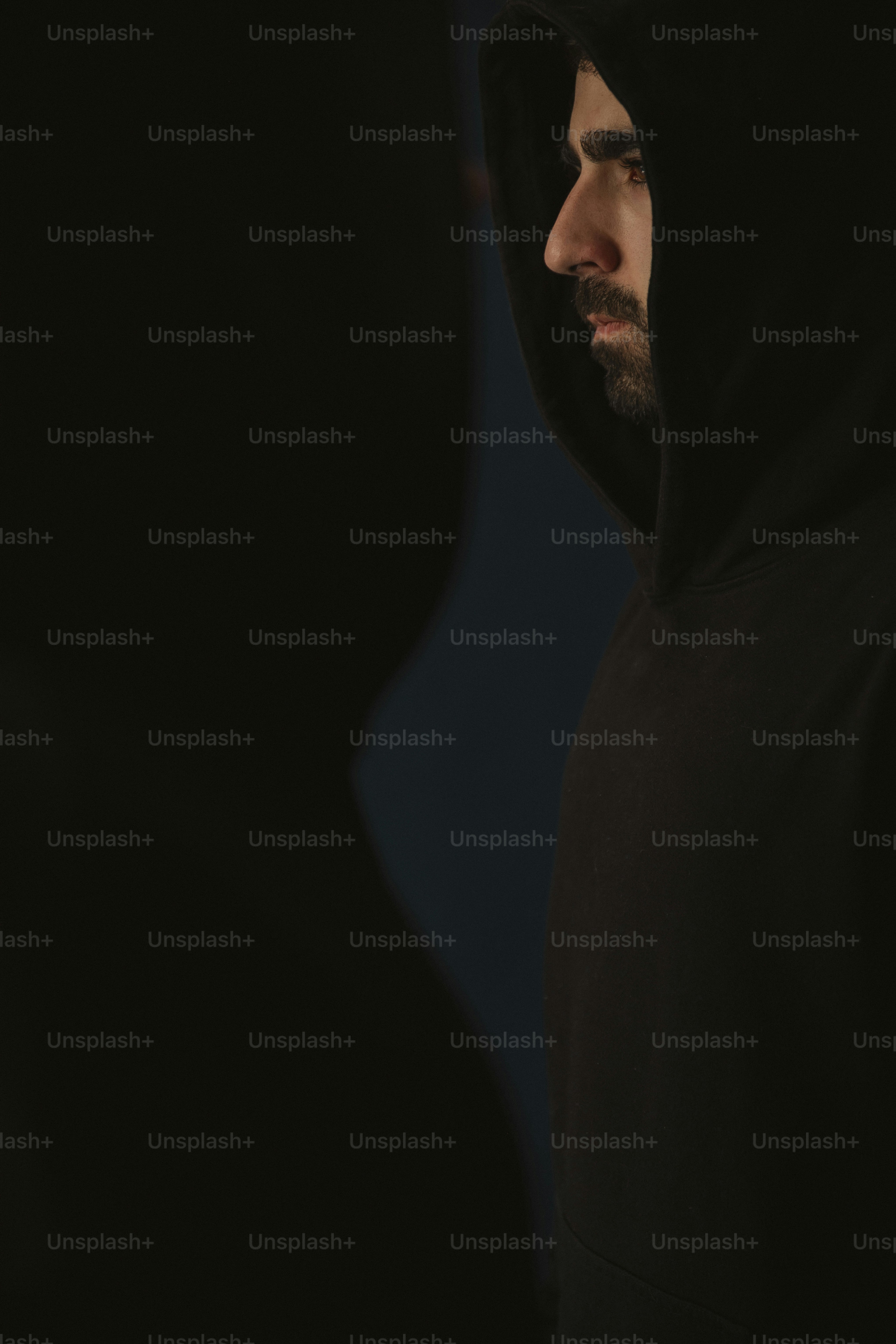 a man in a black hoodie looking away from the camera