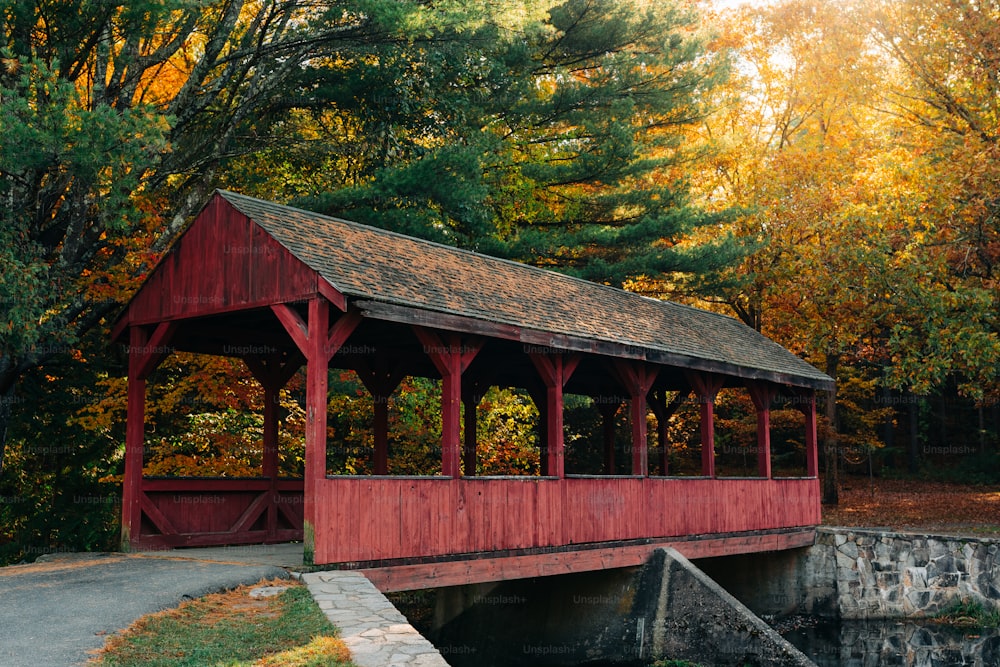 a red covered covered bridge in a wooded area