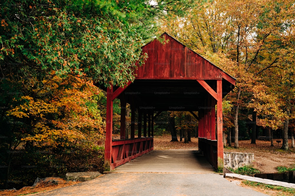 a red covered bridge in a wooded area