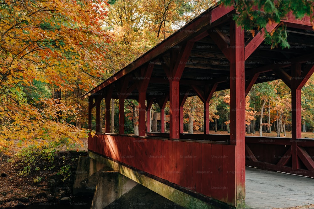 a red covered covered bridge in a park