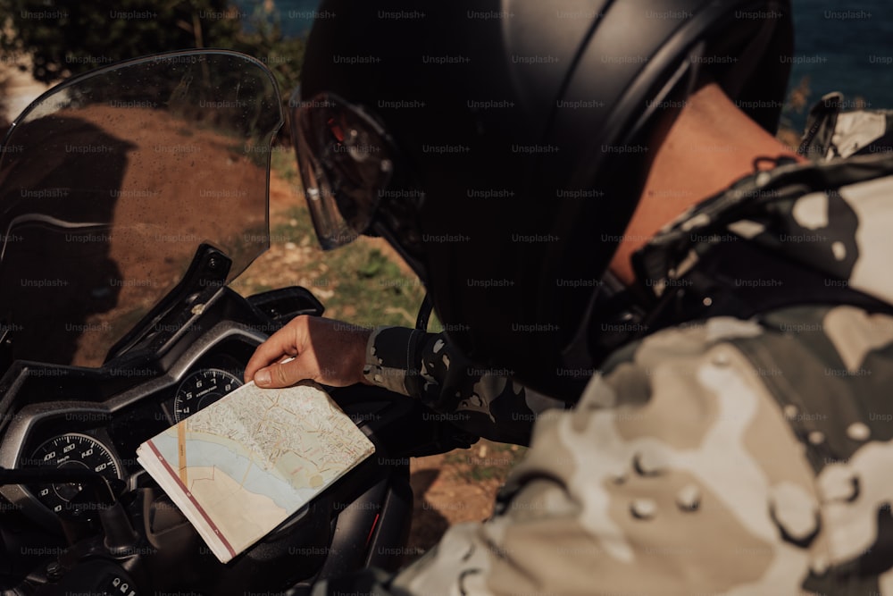 una persona su una motocicletta con una mappa in mano