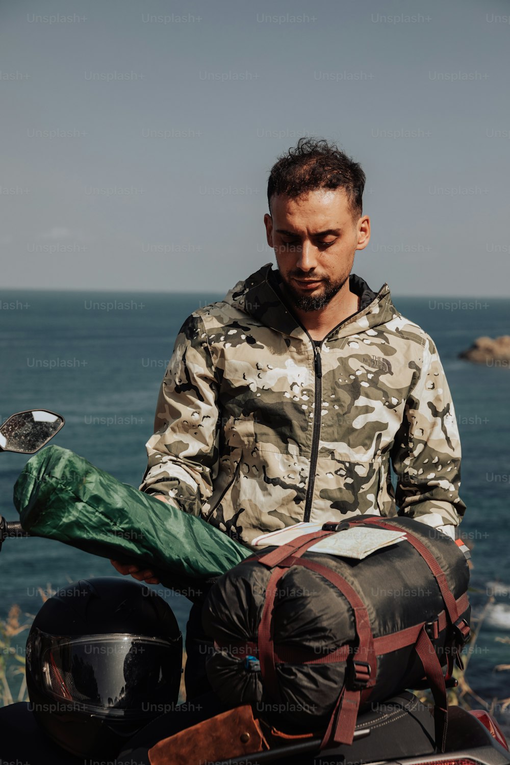un uomo seduto su una motocicletta vicino all'oceano