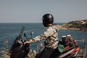 a person on a motor scooter overlooking the ocean