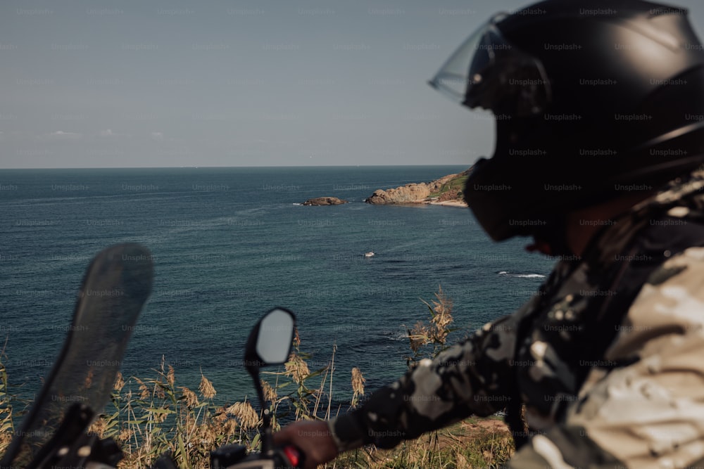 a person on a motorcycle looking out at the ocean