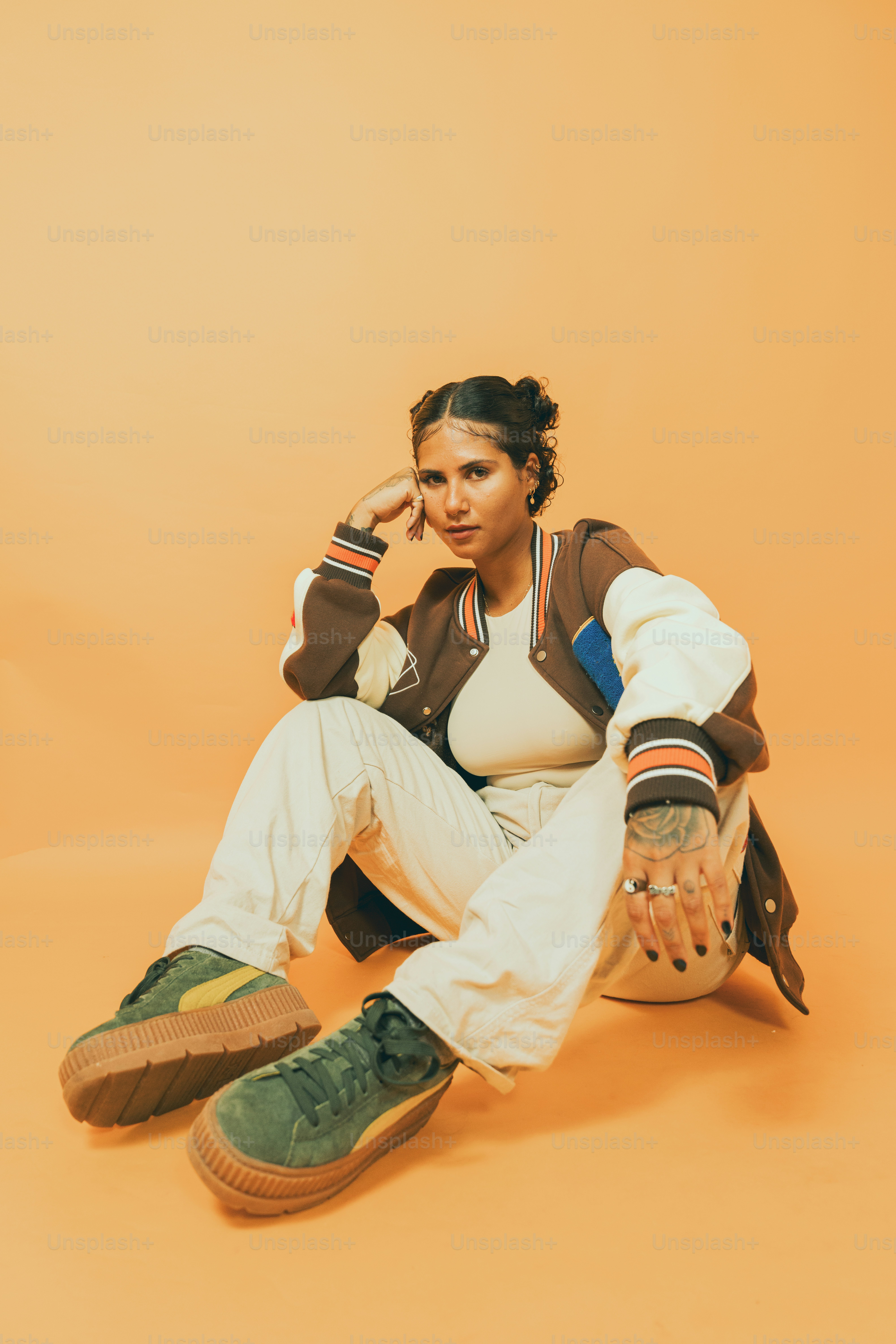 a woman sitting on the ground with her hand on her head