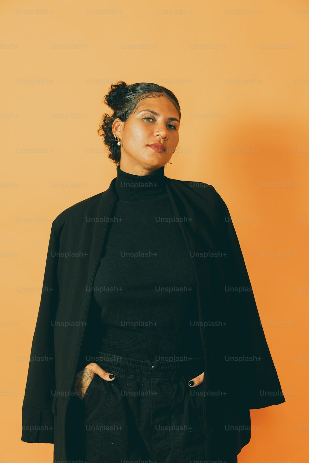 eine Frau trägt eine schwarze Jacke und eine schwarze Hose