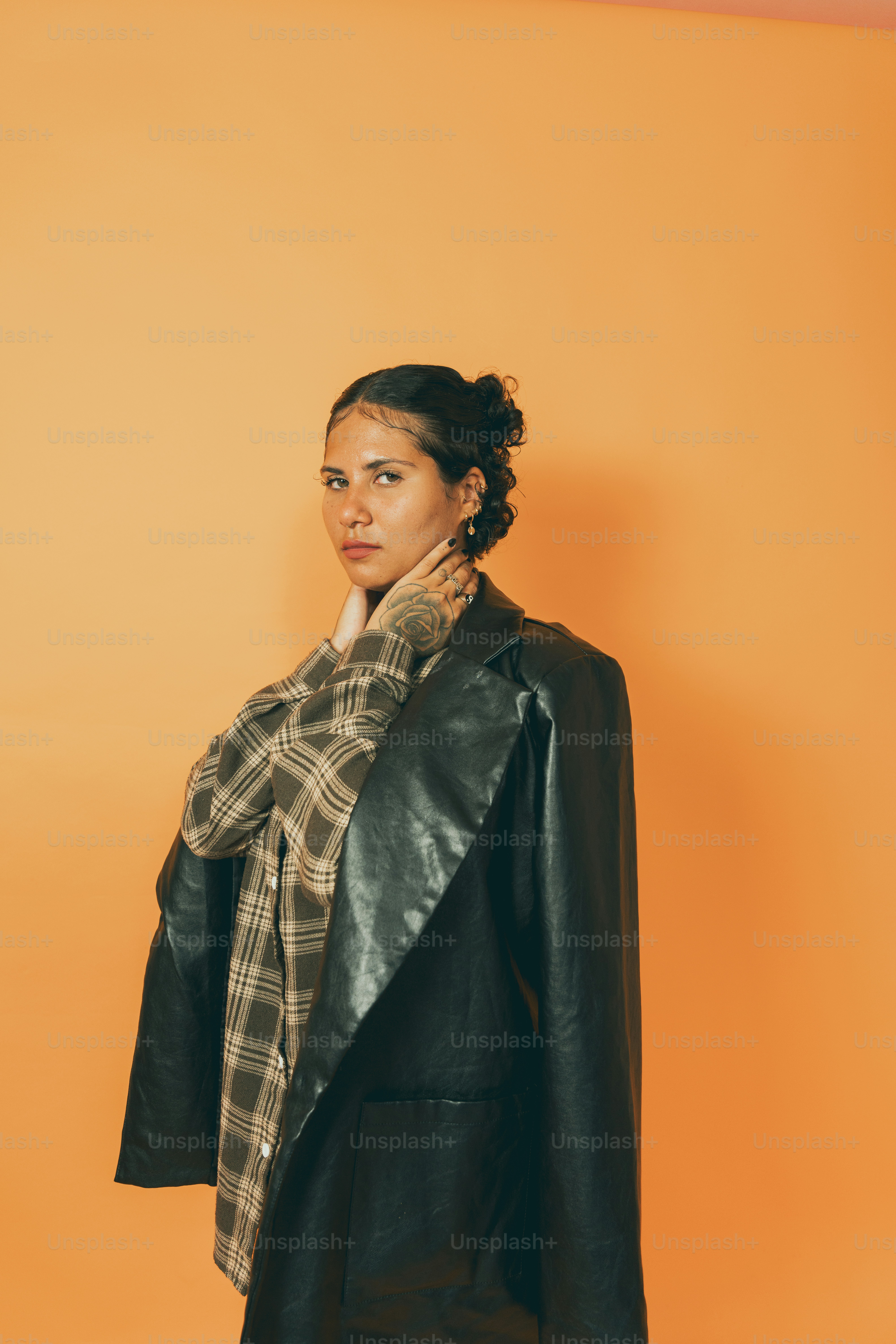 a woman in a black jacket and plaid scarf