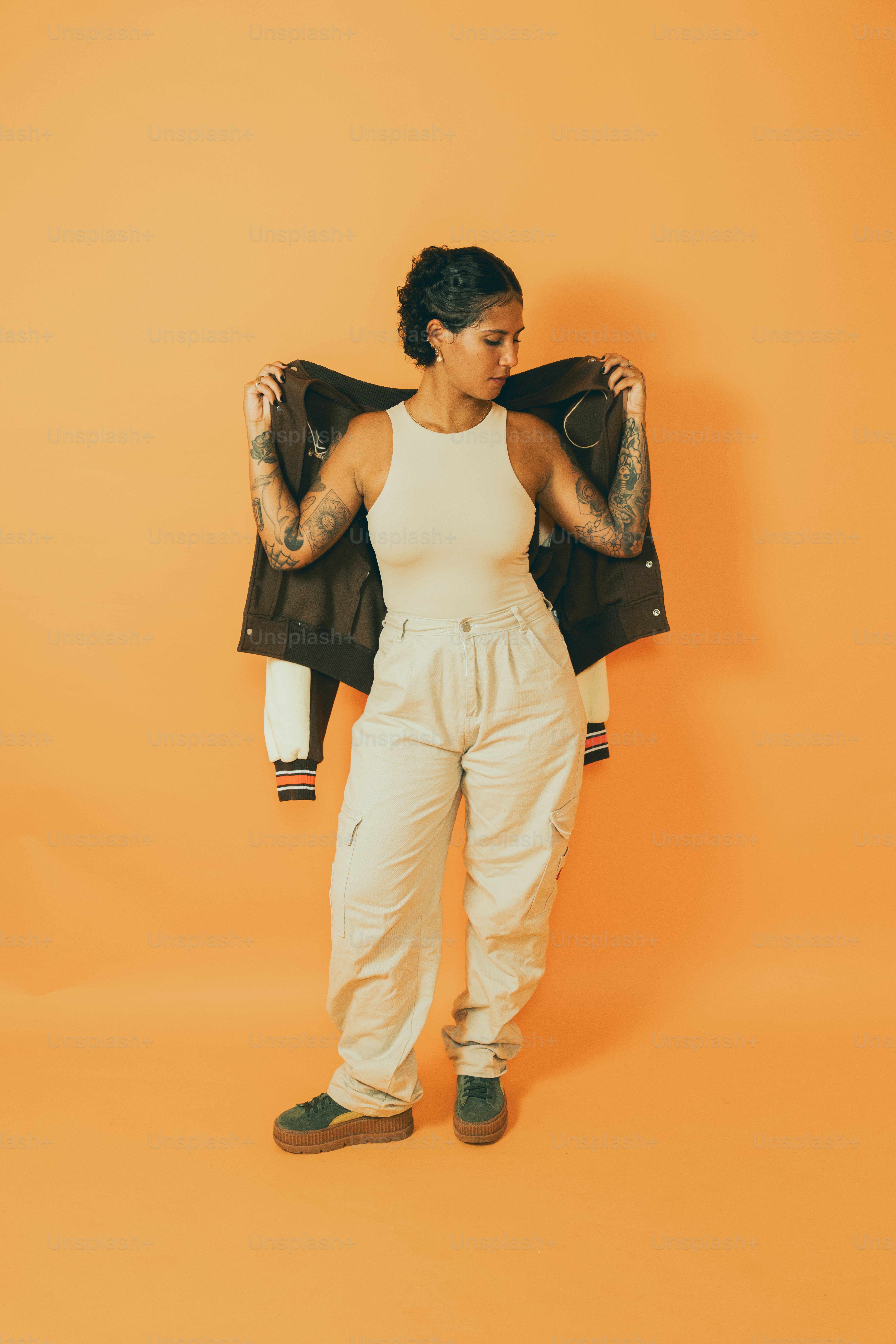 a woman holding a jacket over her shoulder