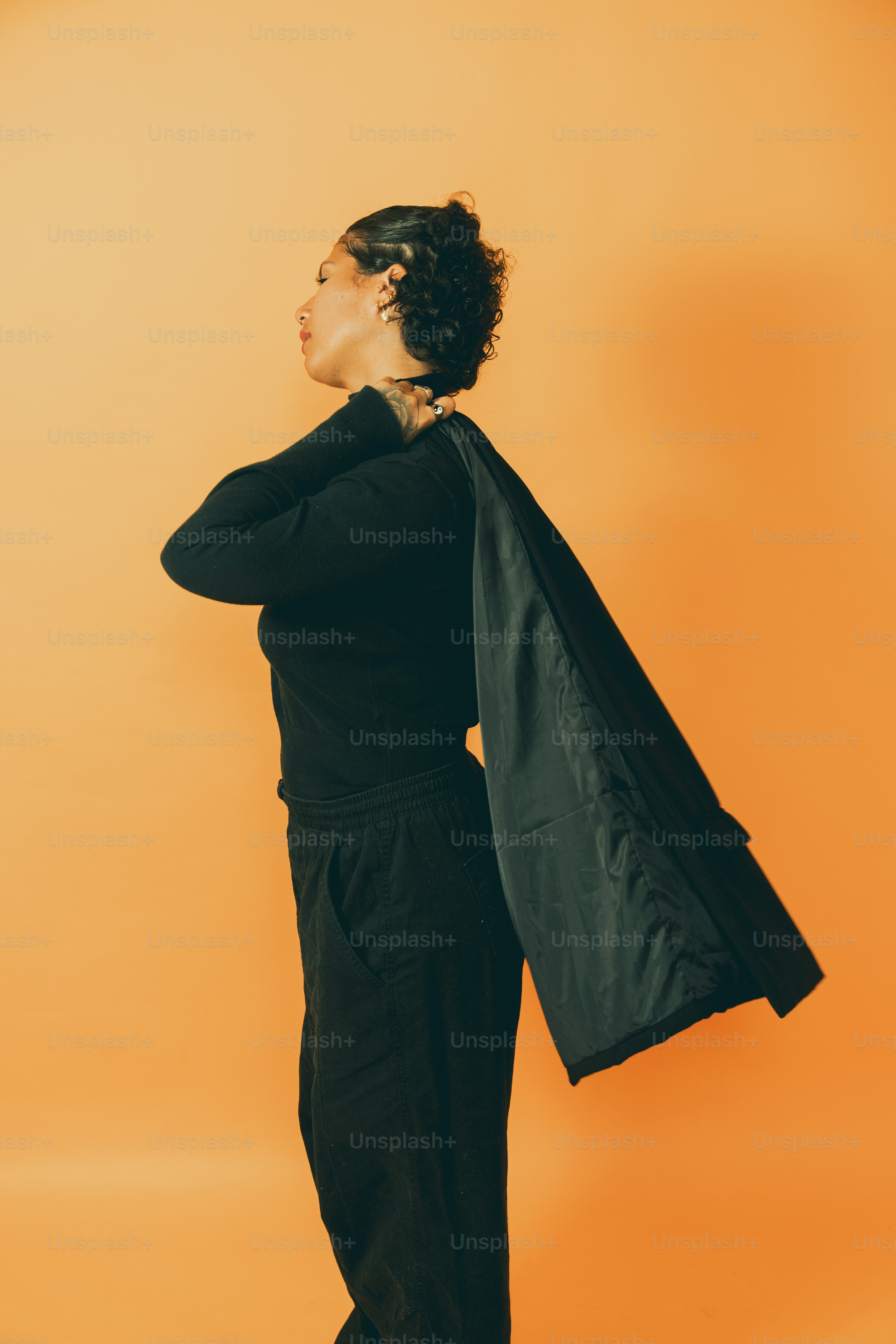 a woman in black is holding a black jacket