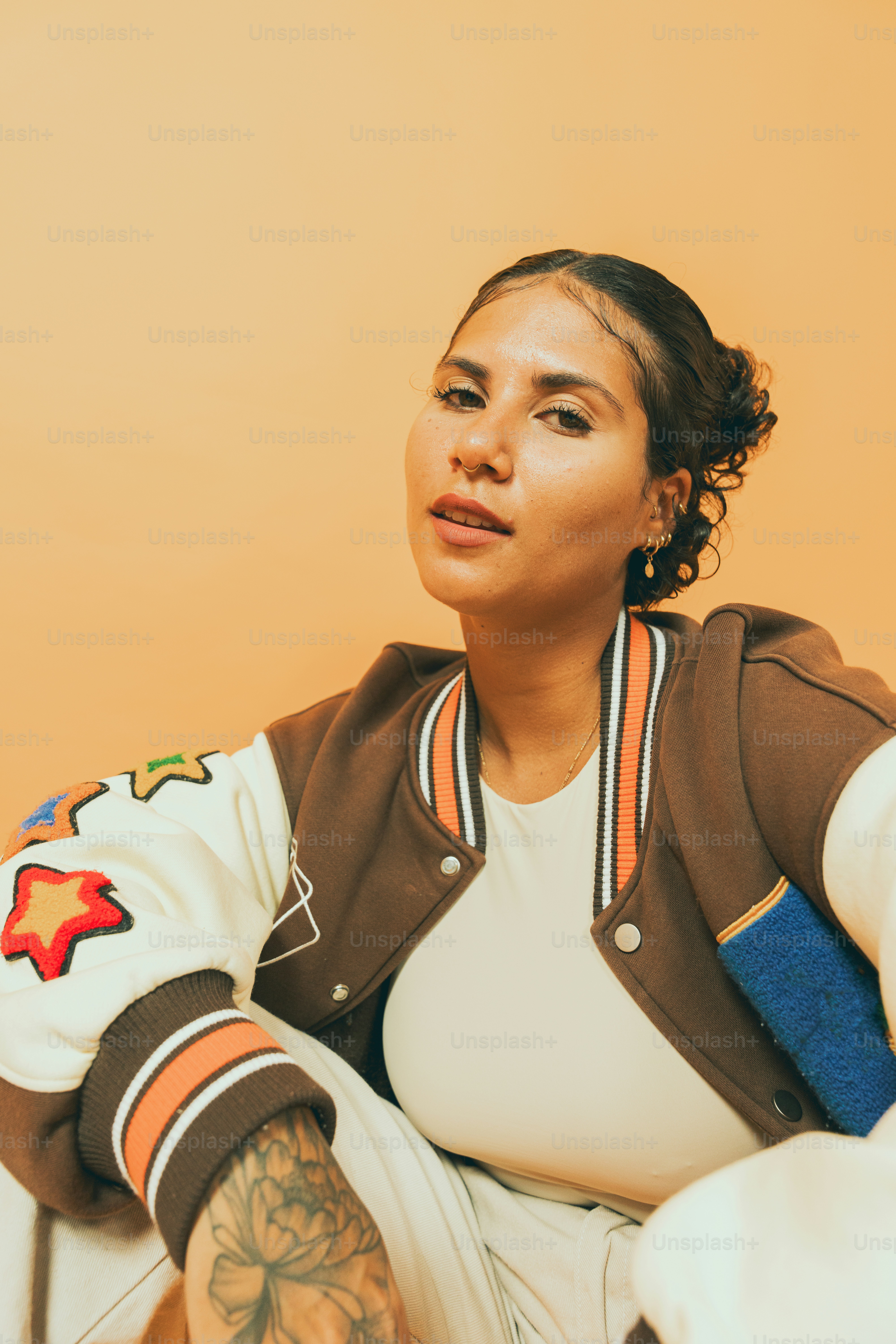a woman sitting on a chair with a tattoo on her arm