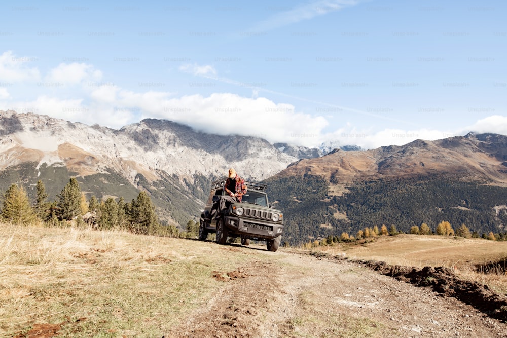 Ein Jeep fährt eine unbefestigte Straße in den Bergen hinunter