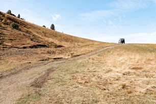 Un camión conduciendo por un camino de tierra en una colina