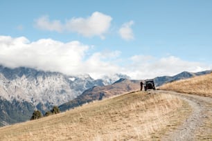 a truck driving down a dirt road in the mountains