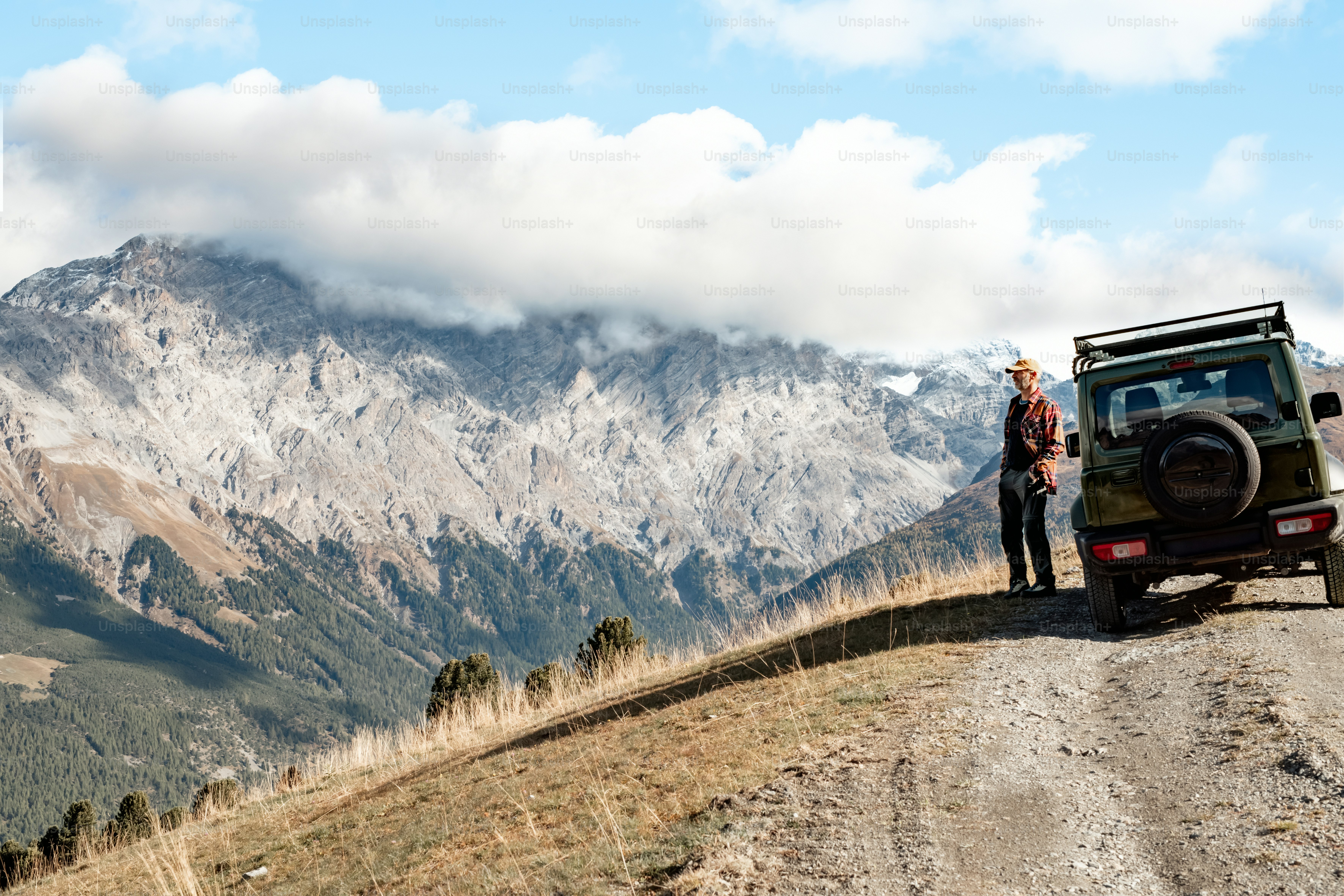 a man standing next to a jeep on a dirt road