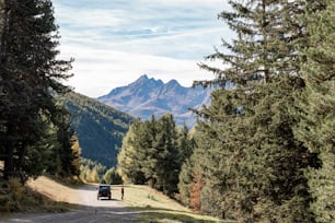 a truck driving down a dirt road in the mountains