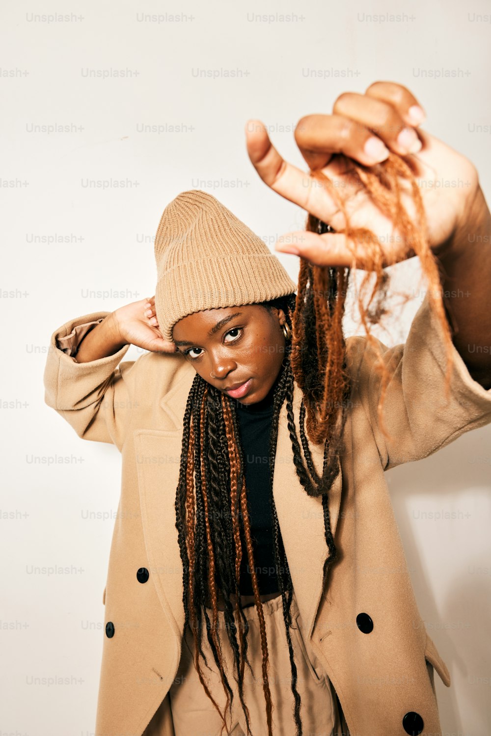 a woman with dreadlocks holding her hands up