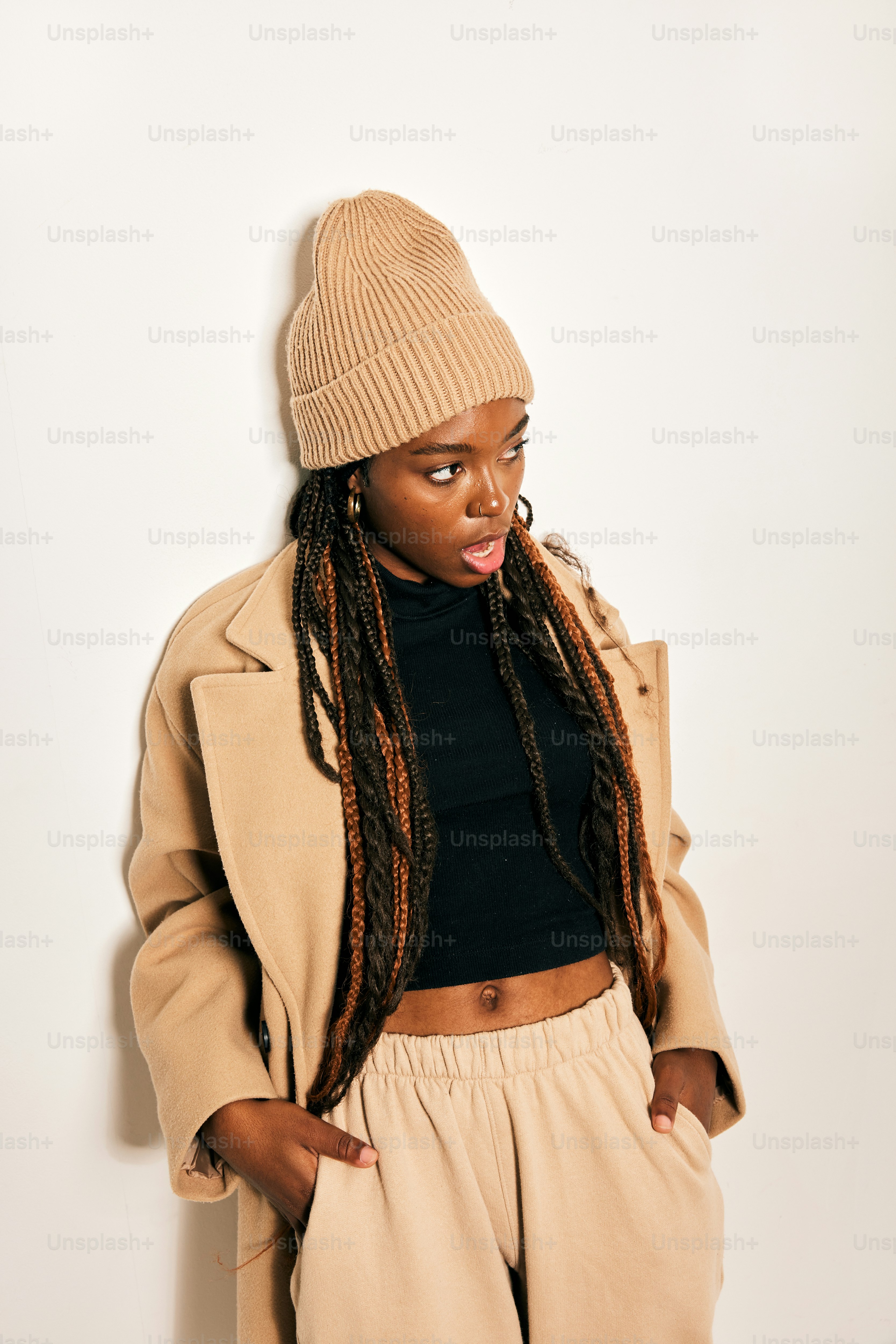 a woman with dreadlocks standing against a wall