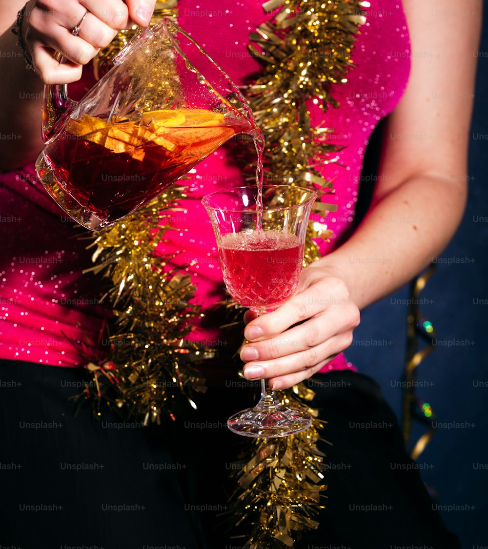 분홍색 드레스를 입은 여자가 와인 한 잔을 들고 있다