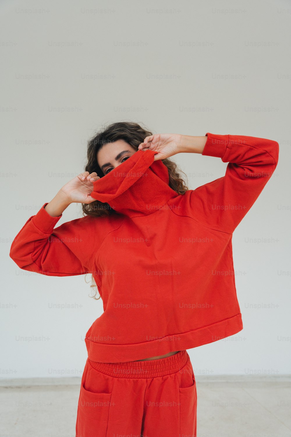 赤いスウェットシャツとズボンを着た女性