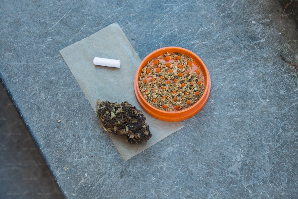 a bowl of food next to a cigarette on a piece of paper