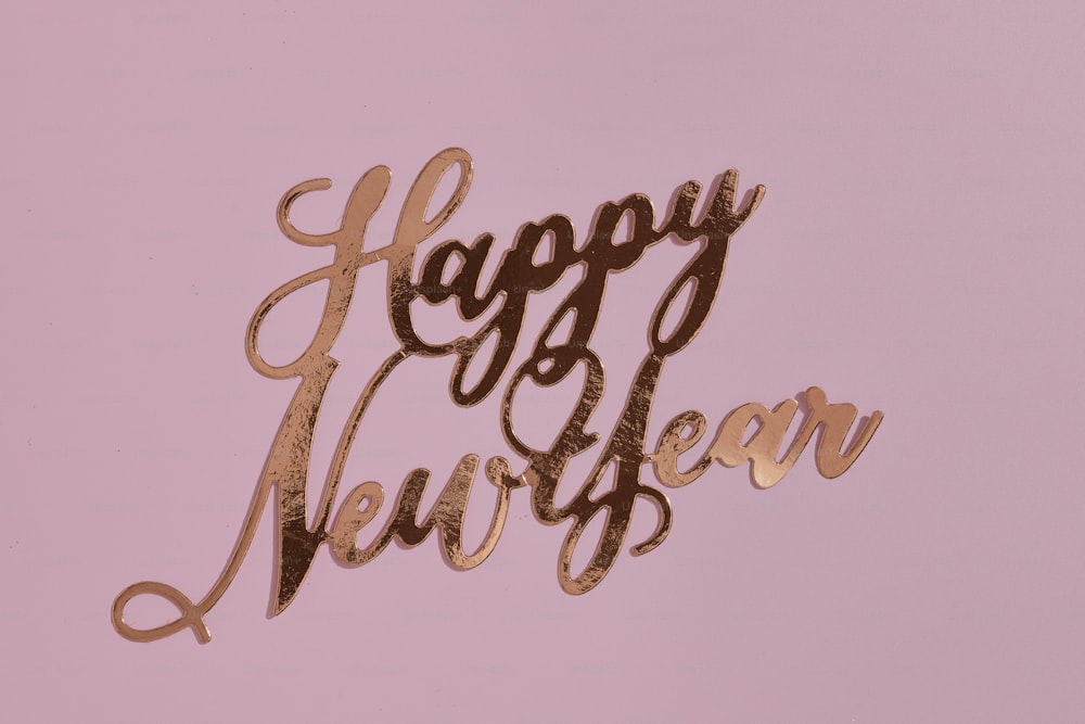 a happy new year cake topper on a pink background