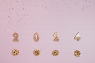 a pink background with gold numbers and bows