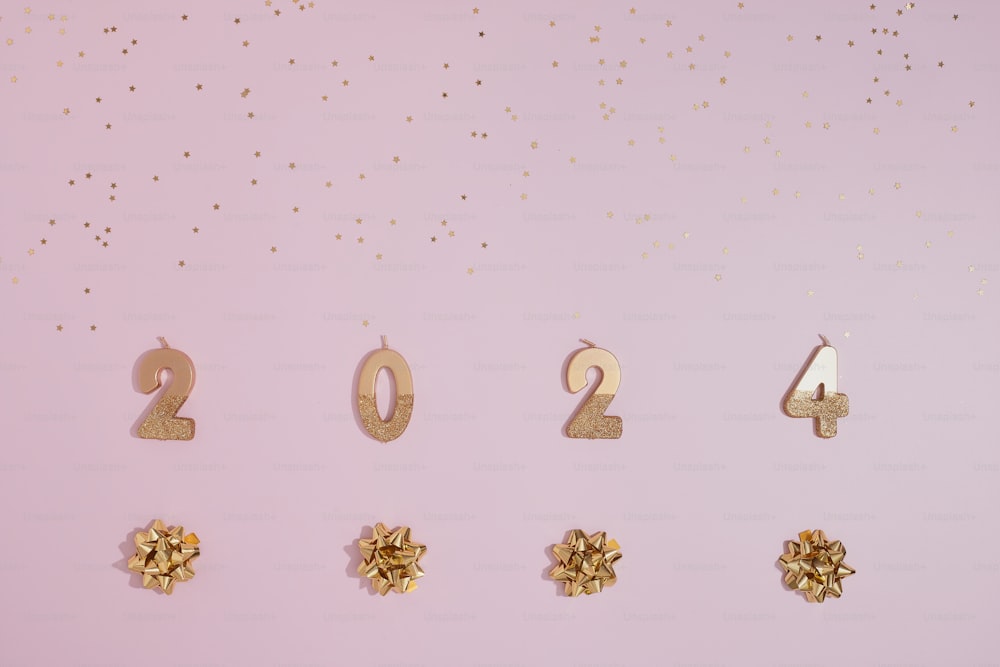 a pink background with gold numbers and bows