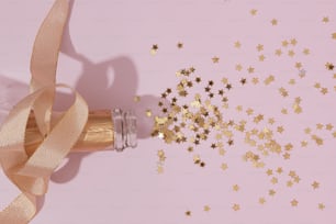 a bottle of champagne with gold stars on a pink background
