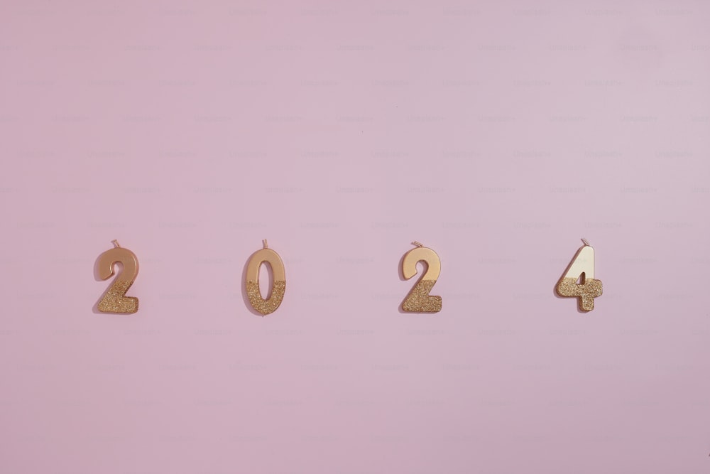 una serie de números dorados sobre un fondo rosa