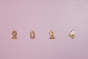 a number of gold numbers on a pink background