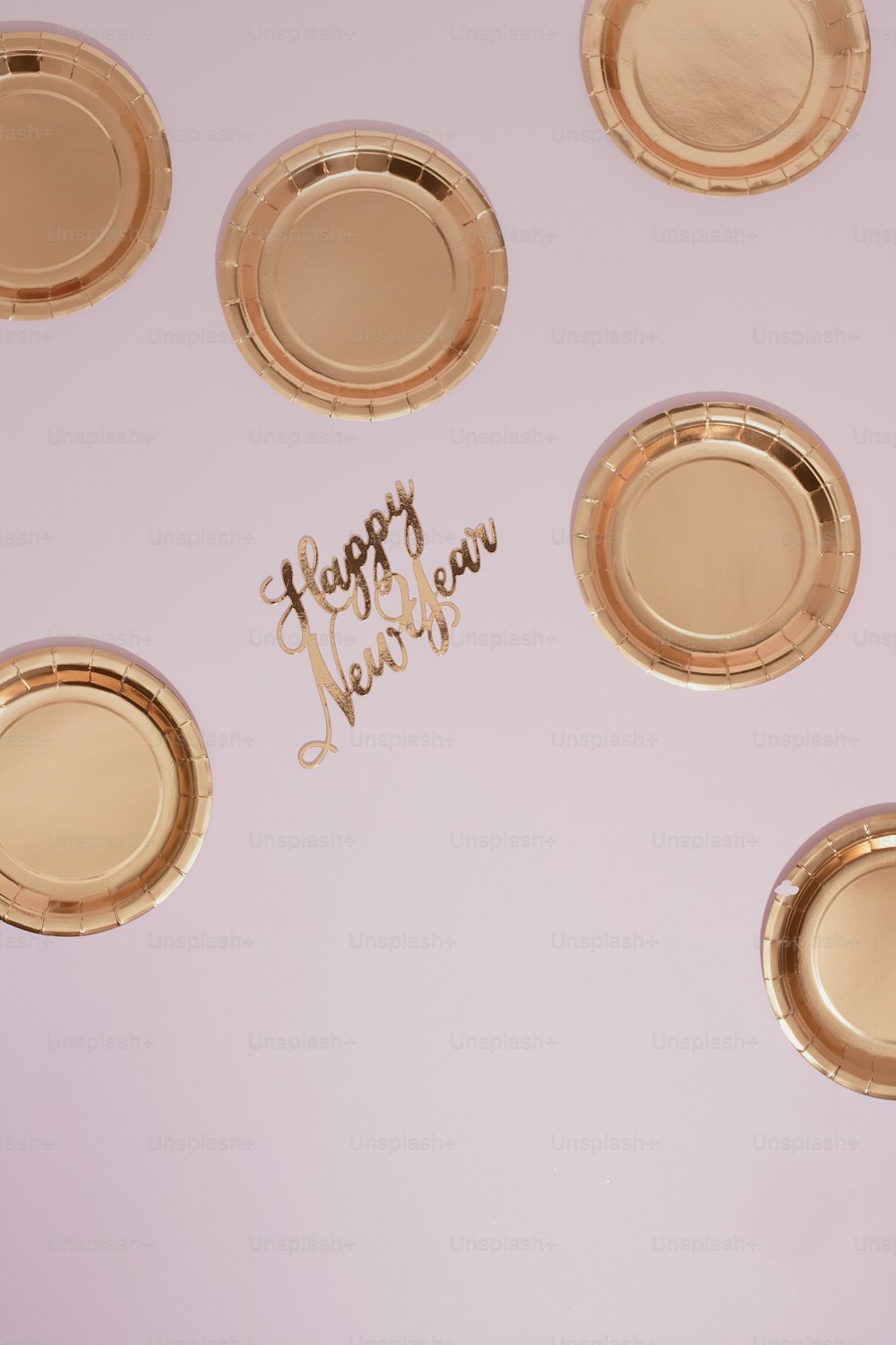 Felice Anno Nuovo scritto su un tavolo con piatti d'oro