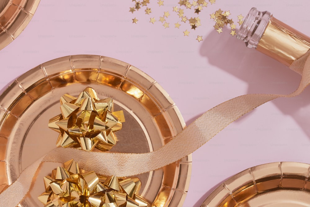 una mesa rosa coronada con platos de oro cubiertos de lazos