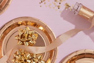 a pink table topped with gold plates covered in bows