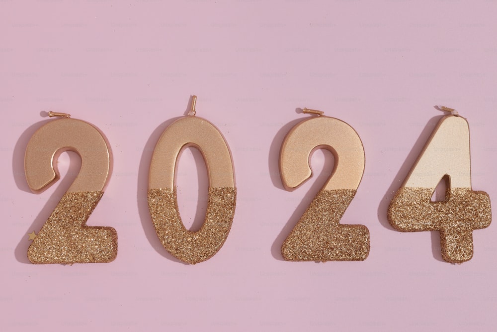 a number of gold numbers on a pink background